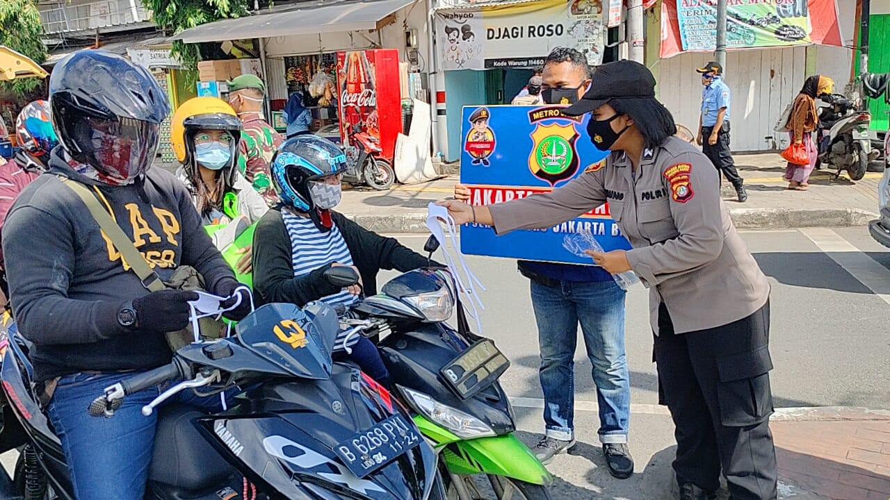 Polwan bagikan ratusan masker di Trafic light TL Grogol, Jakarta. (Foto: PMJ News). 