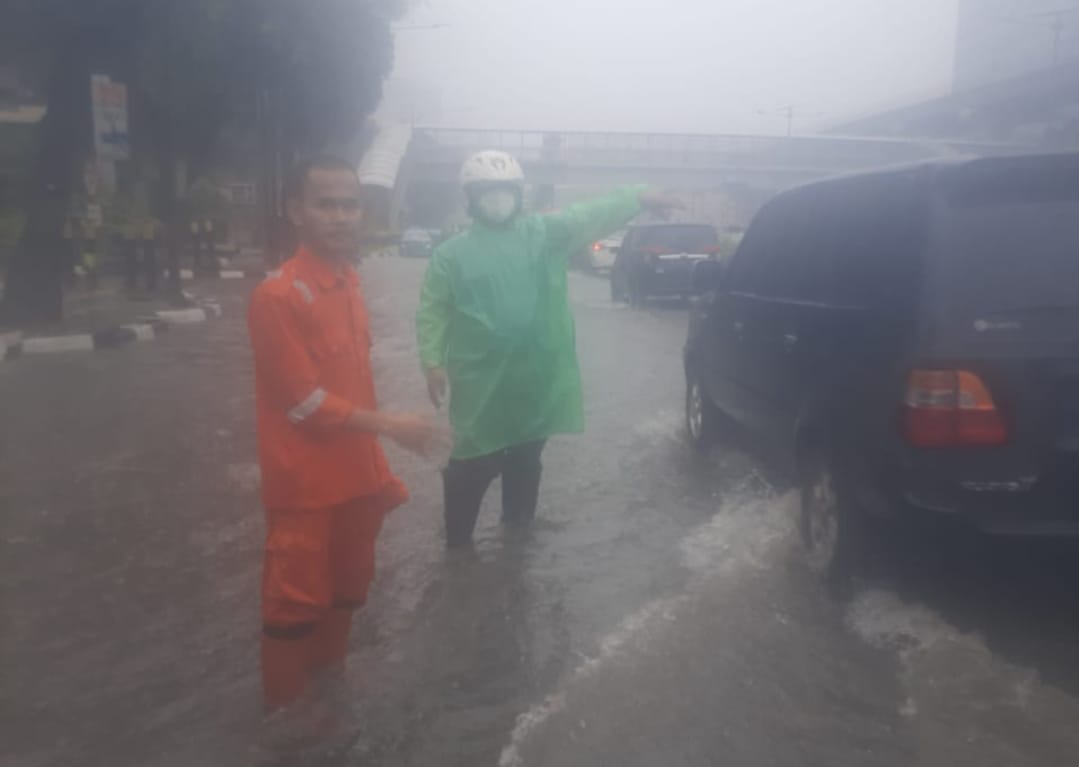 Polisi tengah mengatur lalin atasi kemacetan di kawasan Gatsu Jaksel karena tergenang air hujan. (Foto: Twitter TMC). 