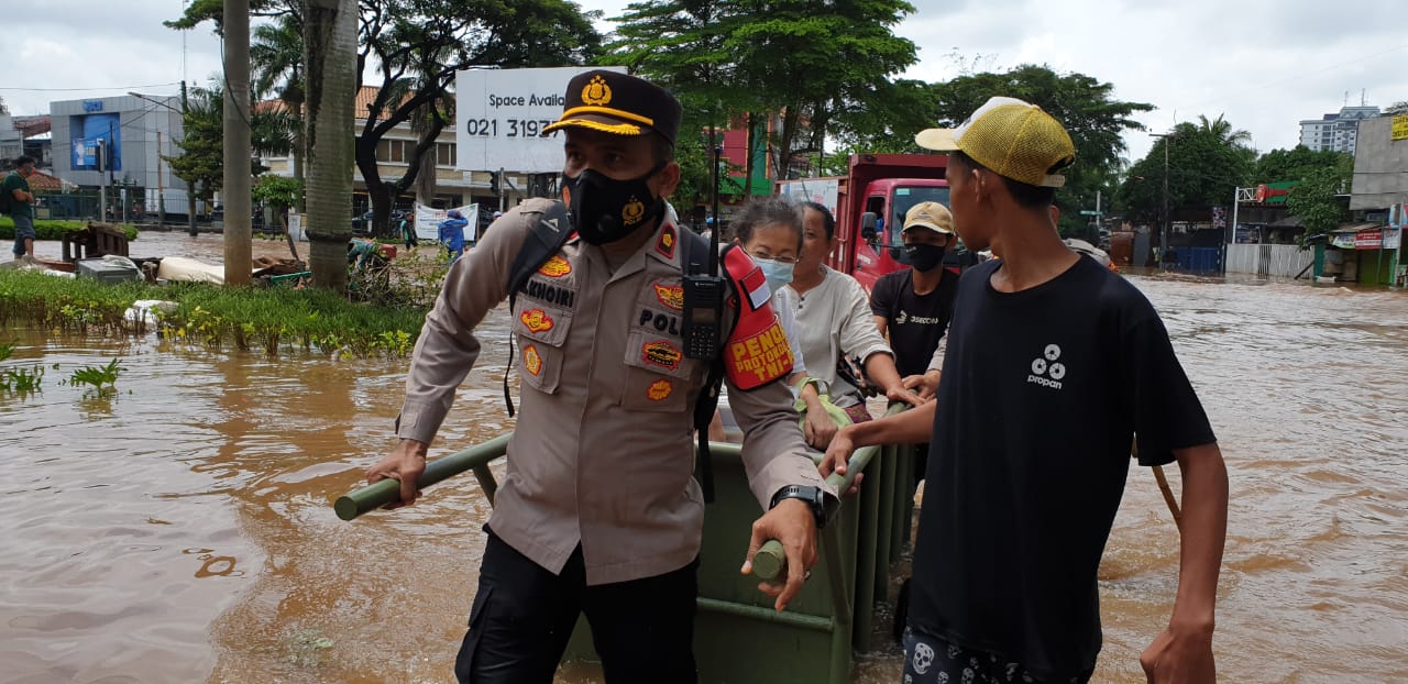 Kapolsek Kembangan dan jajarannya dengan ikhlas membantu evakuasi warga yang terjebak banjir menuju rumahnya. (Foto: PMJ News). 