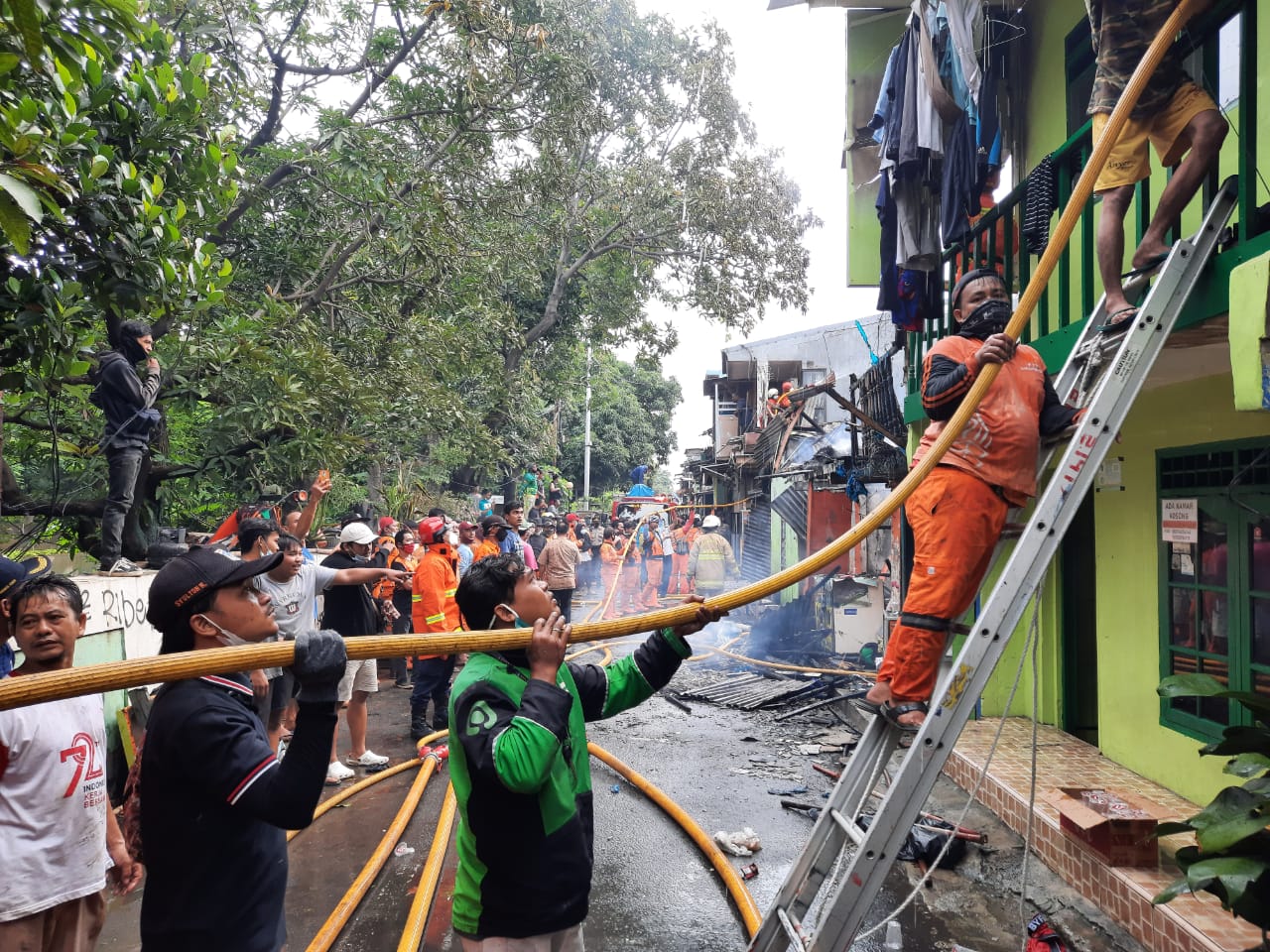 Polisi bersama petugas damkar membantu memadamkan api serta korban kebakaran di Kelapa Gading Jakut. (Foto: PMJ News). 