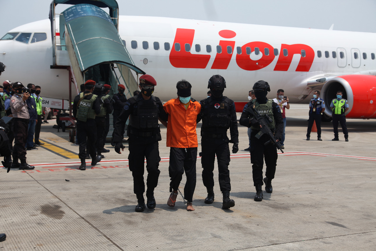 Anggota tim Densus 88 Antiteror mengawal ketat 22 terduga teroris di Parking Stand K13 Area Apron Terminal Cargo Bandara Soekarno-Hatta. (Foto: PMJ News). 