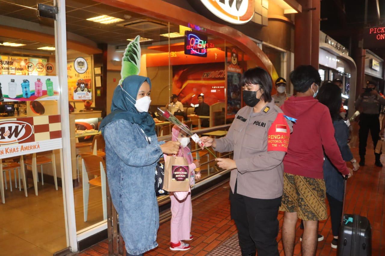 Polwan membagikan makanan sahur dan bunga untuk pengunjung di area Terminal 2 Bandara Soekarno-Hatta. (Foto: PMJ News). 