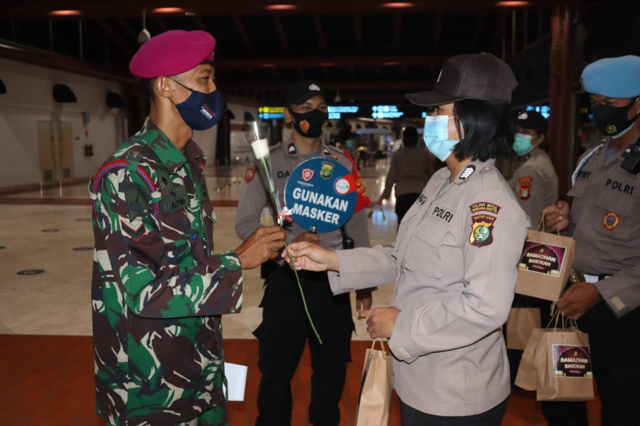 Polwan membagikan makanan sahur dan bunga untuk pengunjung di area Terminal 2 Bandara Soekarno-Hatta. (Foto: PMJ News). 