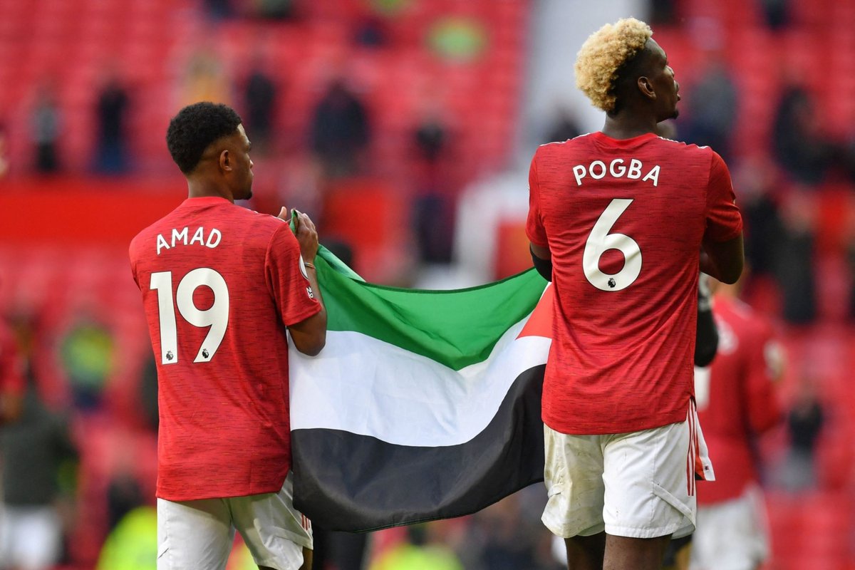 Paul Pogba bersama Amad Diallo membentangkan bendera Palestina di Old Trafford. (Foto: Dok Net)