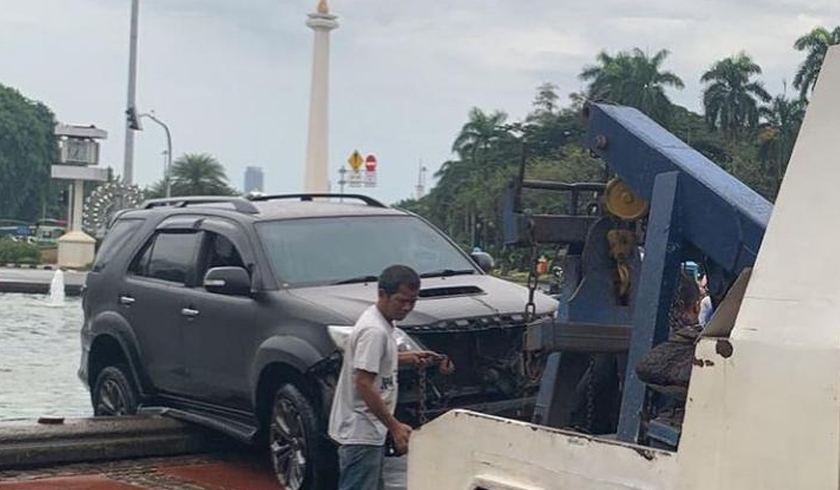 Mobil Toyota Fortuner berpelat nomor B 1893 KLT masuk ke dalam kolam air mancur yang berada di Bundaran Patung Kuda, Jakarta. (Foto: PMJ News/Instagram @jktinfo),