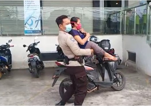 Ajun Inspektur Dua Agus Riyanto membopong penyandang disabilitas dapatkan vaksinasi. (Foto: PMJ News). 