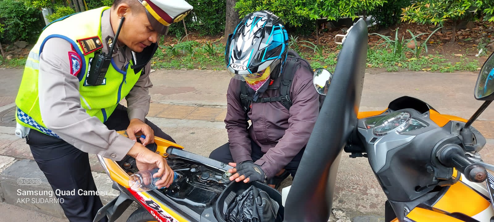 Satlantas Jakbar berikan bantuan bensin untuk pengendara yang motornya mogok. (Foto: PMJ News). 