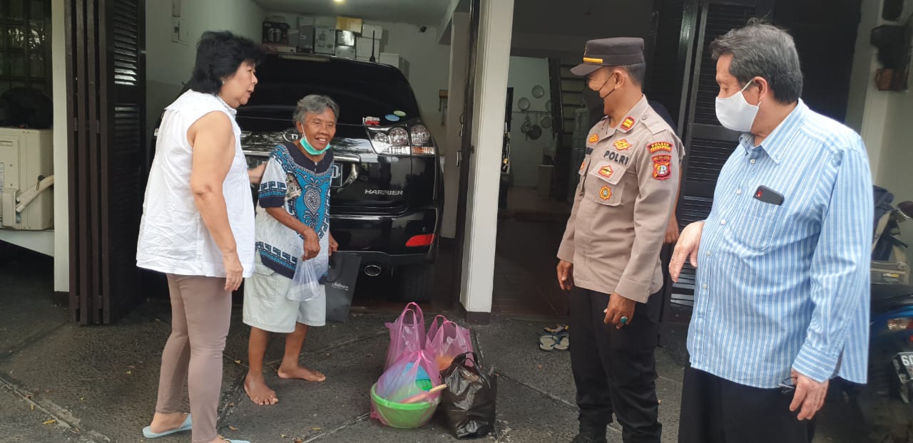 Anggota Polsek Kembangan mengantarkan nenek lansia ke rumah majikannya. (Foto: PMJ News)