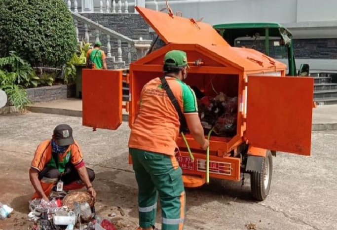 Petugas kebersihan atau pasukan oranye membersihkan sampah. (Foto: PMJ News/Instagram @dinaslhdki).