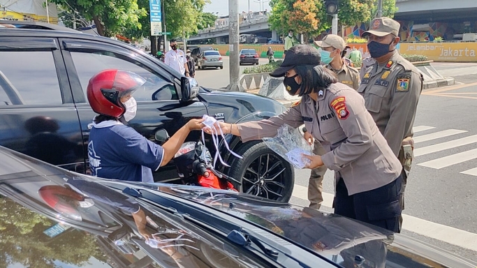 Polwan bagikan ratusan masker di Trafic light TL Grogol, Jakarta. (Foto: PMJ News). 
