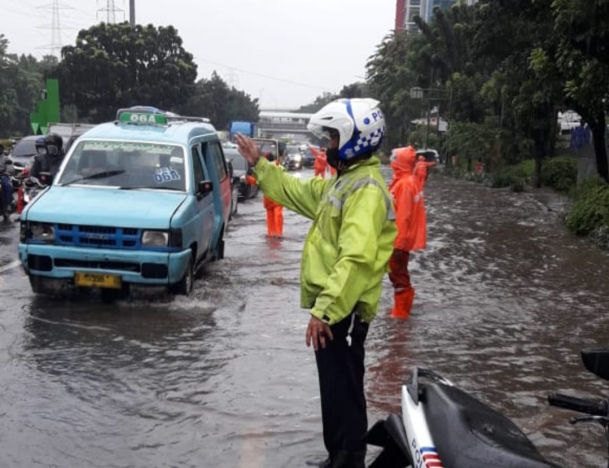 Polisi tengah mengatur lalin atasi kemacetan di kawasan Gatsu Jaksel karena tergenang air hujan. (Foto: Twitter TMC). 