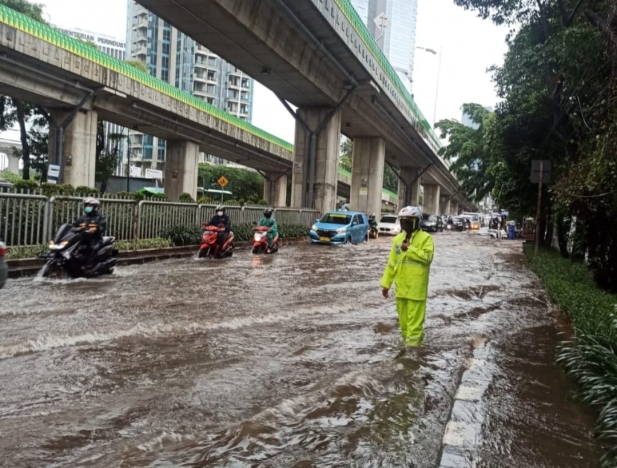 Polisi tengah mengatur lalin di wilayah Mampang menuju Kemang Jakarta Selatan, yang tergenang air banjir. (Foto: Twitter  TMC). 