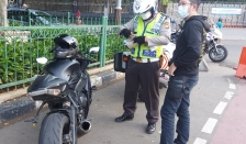 Seorang pemotor ditilang Satlantas Polres Jakpus karena knalpotnya bersuara bising. (Foto: PMJ News/TMC Polda Metro Jaya)