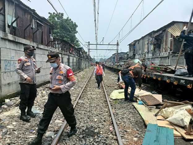 Personel gabungan melakukan pengamanan penertiban bangunan liar atau pemanfaatan lahan tidak berizin di sepanjang jalur rel kereta api. (Foto: PMJ News). 