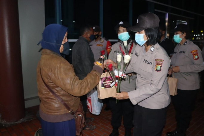 Polwan membagikan makanan sahur dan bunga untuk pengunjung di area Terminal 2 Bandara Soekarno-Hatta. (Foto: PMJ News). 