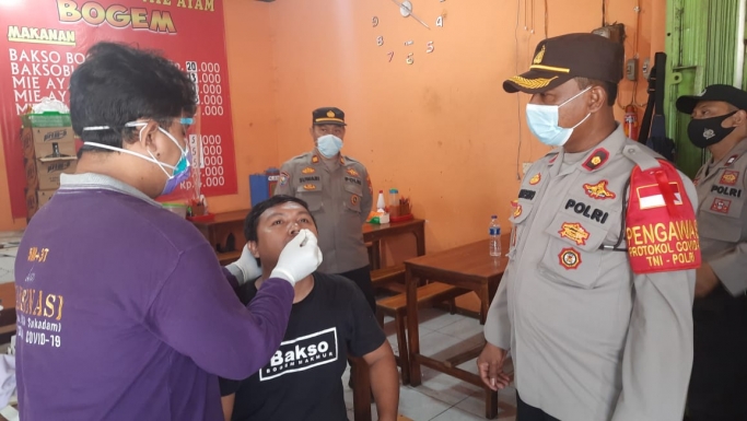 Kapolsek Cikarang Selatan mengawasi swab test para pemudik yang tiba di wilayah Cikarang Selatan. (Foto: PMJ News). 