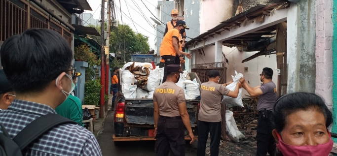 Polsek Tanjung Duren bersama Tiga Pilar melakukan kerja bakti membersihkan puing-puing di area pasca kebakaran . (Foto: PMJ News). 