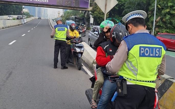 Polisi melakukan penindakan tilang manual terhadap para pemotor yang melintas masuk JLNT Casablanca. (Foto: PMJ News/TMC Polda Metro)