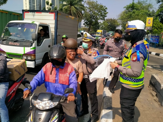 Satlantas Jakarta Barat bagi-bagi helm gratis kepada pengendara. (Foto: PMJ News)