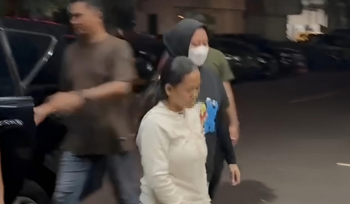 Wanita yang viral di media sosial diduga melakukan perbuatan asusila terhadap anaknya menyerahkan diri ke polisi. (Foto: PMJ News/Fajar)
