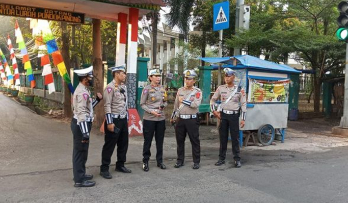 Personel Satlantas Polres Metro Jakarta Selatan disiagakan di depan sekolah untuk menyeberangkan siswa-siswi. (Foto: PMJ News)